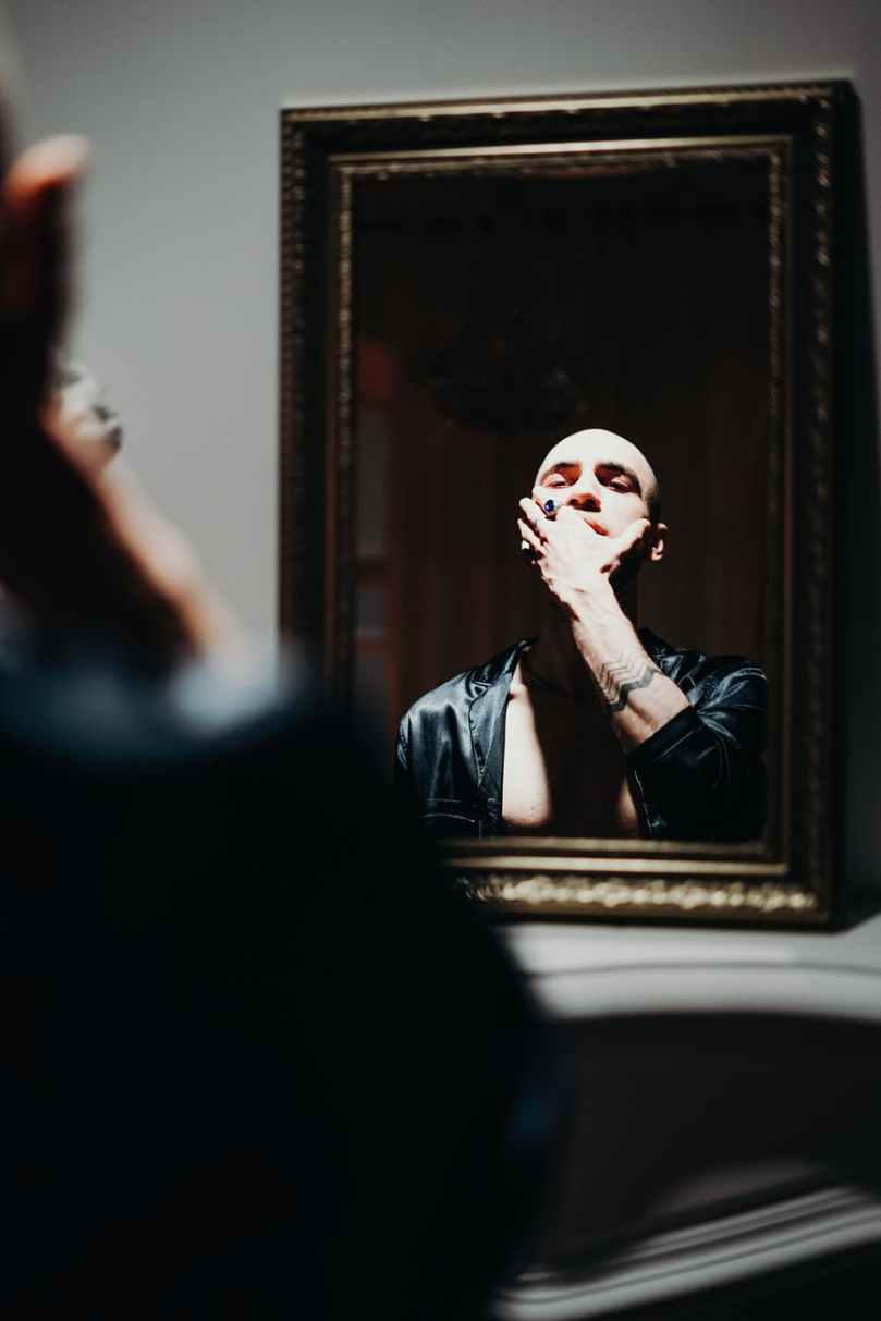 man looking at the mirror in holding his face